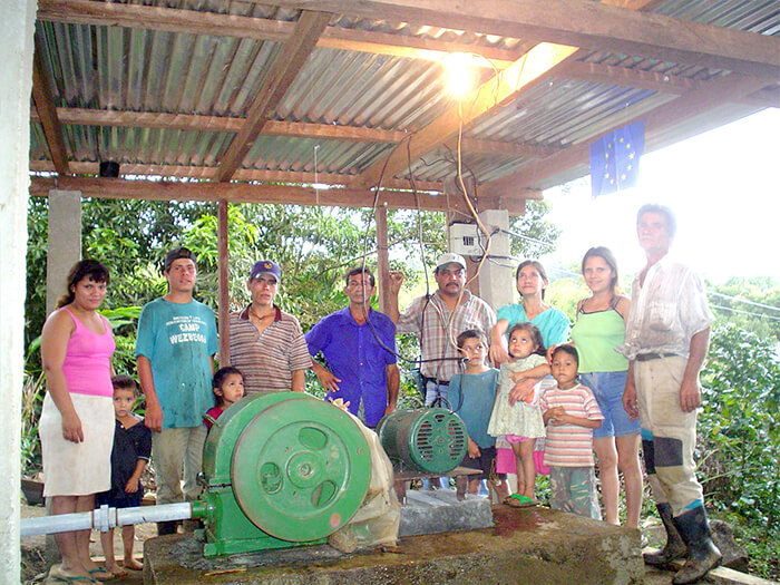 Grupo de personas junto a turbina instalada en una de las comunidadades seleccionadas.